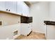 Bright laundry room with white cabinetry, dark hardware, and tiled backsplash at 15387 W Columbine Dr, Surprise, AZ 85379
