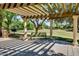Community park featuring a pergola, a bench, and lush green trees providing a shaded area for relaxation at 15387 W Columbine Dr, Surprise, AZ 85379