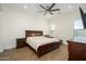 Comfortable bedroom with dark wood furniture, a ceiling fan, and natural light from the window at 16368 W Watkins St, Goodyear, AZ 85338