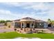 Grand home exterior with a circular portico entrance, lush landscaping, and stone accents at 16368 W Watkins St, Goodyear, AZ 85338