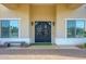 Inviting front entrance with an ornate iron door, decorative sconces, and a charming bench at 16368 W Watkins St, Goodyear, AZ 85338