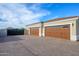 Spacious three-car garage with stylish doors and ample parking space on a paved driveway at 16368 W Watkins St, Goodyear, AZ 85338
