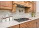 Close-up of stove top and custom cabinets in the kitchen with granite countertops and designer details at 16368 W Watkins St, Goodyear, AZ 85338