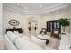 Bright living space featuring white sofas, tile flooring, leather chairs, and views to the kitchen at 16368 W Watkins St, Goodyear, AZ 85338