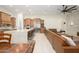 Bright, open-concept area with custom wood cabinets, stainless appliances, and a brown leather sectional at 16368 W Watkins St, Goodyear, AZ 85338