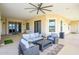 Relaxing covered patio features a comfortable seating arrangement and a ceiling fan, ideal for outdoor living and entertaining at 16368 W Watkins St, Goodyear, AZ 85338