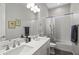 Bright bathroom featuring a double sink vanity, tiled shower and bathtub combination, and modern fixtures at 18129 N 65Th Pl, Phoenix, AZ 85054