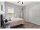 Cozy bedroom with wood-look floors, a plush bed, a ceiling fan, and a built-in closet for ample storage space at 18129 N 65Th Pl, Phoenix, AZ 85054