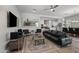 Open-concept living room with modern furnishings, a black leather sofa, and seamless flow into a well-appointed kitchen at 18129 N 65Th Pl, Phoenix, AZ 85054