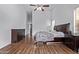 Bedroom with hardwood floors, ceiling fan, dresser, and a bed lit with natural light at 2085 E Ebony Dr, Chandler, AZ 85286