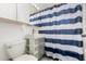 Bathroom with a striped shower curtain, bright lights, and essential fixtures at 2122 W Piccadilly Rd, Phoenix, AZ 85015