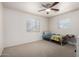 Bright bedroom featuring neutral carpet, ceiling fan, and natural light from two windows at 2122 W Piccadilly Rd, Phoenix, AZ 85015