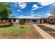 Single-story home featuring mature trees, a landscaped front yard, and a covered carport at 2122 W Piccadilly Rd, Phoenix, AZ 85015