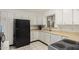 Functional kitchen with white cabinets, black appliances, and tile flooring at 2122 W Piccadilly Rd, Phoenix, AZ 85015