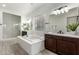 Bright bathroom features dual sinks, white countertop, soaking tub, and glass enclosed shower at 22714 E Parkside Dr, Queen Creek, AZ 85142