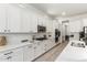 Modern kitchen with white cabinetry, quartz countertops, stainless steel appliances, and wood-look tile floors at 22714 E Parkside Dr, Queen Creek, AZ 85142
