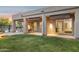 Backyard with covered patio, grassy area, and views through the sliding glass doors at 28045 N 112Th Pl, Scottsdale, AZ 85262