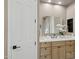 Bathroom with a large mirror, a beautiful vanity with plants, black hardware, and white door at 28045 N 112Th Pl, Scottsdale, AZ 85262