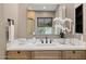 Bathroom with a large mirror, a beautiful vanity with plants, and black hardware at 28045 N 112Th Pl, Scottsdale, AZ 85262