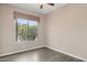 This bedroom features hardwood floors, a ceiling fan, and a window with a view of desert landscaping at 28045 N 112Th Pl, Scottsdale, AZ 85262