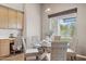 Charming dining area featuring a glass-top table, wicker chairs, and a sunlit window showcasing the outdoor scenery at 28045 N 112Th Pl, Scottsdale, AZ 85262