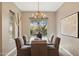 Formal dining room with chandelier, dark wood table, six upholstered chairs, and outside view at 28045 N 112Th Pl, Scottsdale, AZ 85262