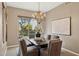 Formal dining room with chandelier, dark wood table, six upholstered chairs, and outside view at 28045 N 112Th Pl, Scottsdale, AZ 85262