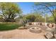 Outdoor area with built-in seating and fire pit surrounded by lush greenery at 28045 N 112Th Pl, Scottsdale, AZ 85262