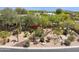 Lush desert landscaping featuring native plants, gravel, and stone accents creates a welcoming outdoor space at 28045 N 112Th Pl, Scottsdale, AZ 85262