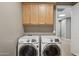 The laundry room includes a modern washer and dryer with built-in cabinets above at 28045 N 112Th Pl, Scottsdale, AZ 85262