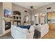 Bright living room with modern fireplace, TV, and large white sofa with view to dining area at 28045 N 112Th Pl, Scottsdale, AZ 85262