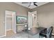 Well-lit home office with a modern desk, decor, and a flatscreen TV mounted on the wall at 28045 N 112Th Pl, Scottsdale, AZ 85262