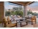 Covered patio features a seating area with comfortable chairs, fire pit, and grill at 28045 N 112Th Pl, Scottsdale, AZ 85262