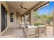 The covered patio area features a ceiling fan and comfortable seating, ideal for relaxing at 28045 N 112Th Pl, Scottsdale, AZ 85262