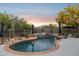 Beautiful backyard pool with mature landscaping and water features under a sunset sky at 28045 N 112Th Pl, Scottsdale, AZ 85262