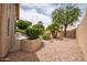 Private backyard with gravel landscaping, lush plants, and a block wall at 3022 N 148Th Ave, Goodyear, AZ 85395