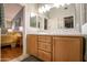 Bathroom featuring double sinks, wood cabinets, and view of the main bedroom at 3022 N 148Th Ave, Goodyear, AZ 85395