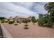 Expansive, well-kept yard with desert landscaping, mature trees, and a view of the single story home at 3022 N 148Th Ave, Goodyear, AZ 85395