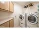 Bright laundry room featuring a modern washer and dryer set with built-in storage at 3022 N 148Th Ave, Goodyear, AZ 85395