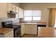 Well-lit kitchen featuring light-colored cabinetry, laminate countertops, and modern appliances at 3559 N 143Rd Ave, Goodyear, AZ 85395