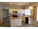 Bright kitchen features white cabinetry, an island, modern appliances, and views into an adjacent room at 3559 N 143Rd Ave, Goodyear, AZ 85395
