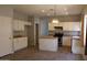 Spacious kitchen with white cabinets, an island, tiled floors, and an adjacent dining area at 3559 N 143Rd Ave, Goodyear, AZ 85395