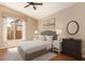 Cozy bedroom features neutral decor, ceiling fan, and large window with neighborhood views at 4923 W Wahalla Ln, Glendale, AZ 85308