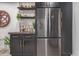 Close-up view of stylish bar area with dark cabinetry, open shelving, and stainless steel refrigerator at 5995 N 78Th St # 2078, Scottsdale, AZ 85250