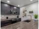 Modern kitchen features sleek black cabinetry with gold hardware, designer wine rack, and stone countertops at 5995 N 78Th St # 2078, Scottsdale, AZ 85250