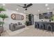 Open-concept living room features a plush gray sofa, unique wall art, and a modern kitchen bar at 5995 N 78Th St # 2078, Scottsdale, AZ 85250