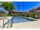 Community pool surrounded by lush greenery and lounge chairs on a sunny day at 5995 N 78Th St # 2078, Scottsdale, AZ 85250