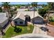 Beautiful aerial view of a home with a tile roof, lush lawn, desert landscaping, and mature palm trees at 6577 W Abraham Ln, Glendale, AZ 85308