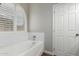 Clean, white bathroom with a tub, subway tile, and shuttered window at 6577 W Abraham Ln, Glendale, AZ 85308