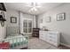 Bright bedroom with a white daybed, dresser, and bookcase with decorative art at 6577 W Abraham Ln, Glendale, AZ 85308